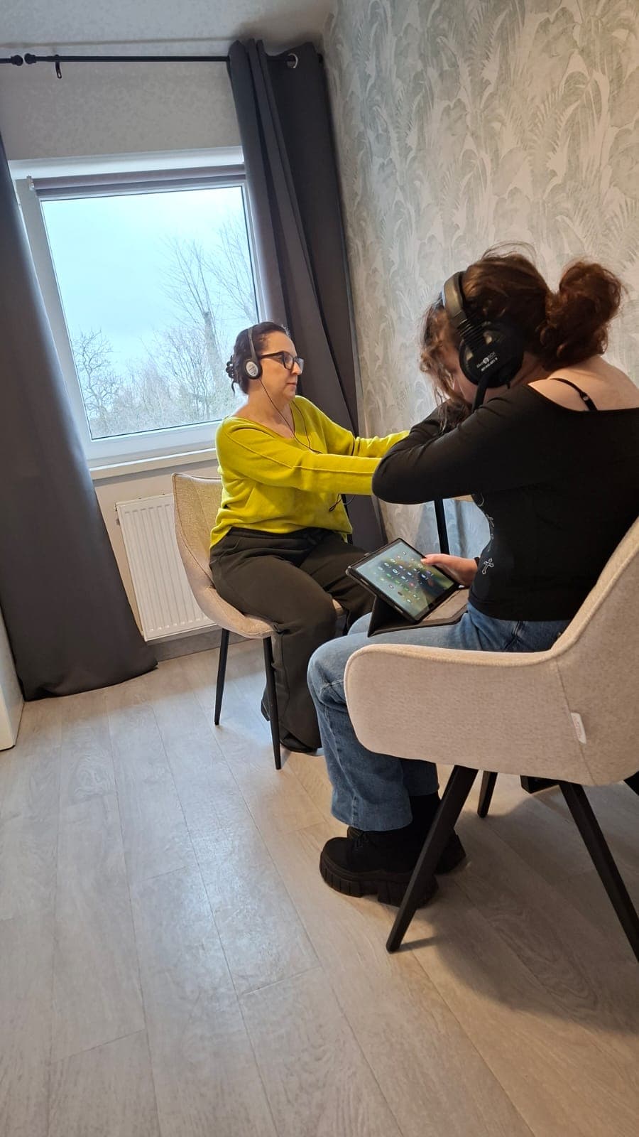 Dziecko podczas treningu słuchowego prowadzonego przez terapeutkę.