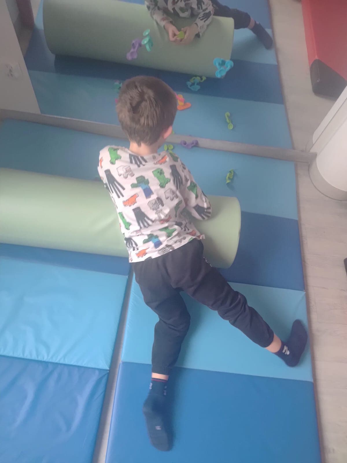 Dziecko wykonuje sensoryczne zadanie manualne przy stoliku.