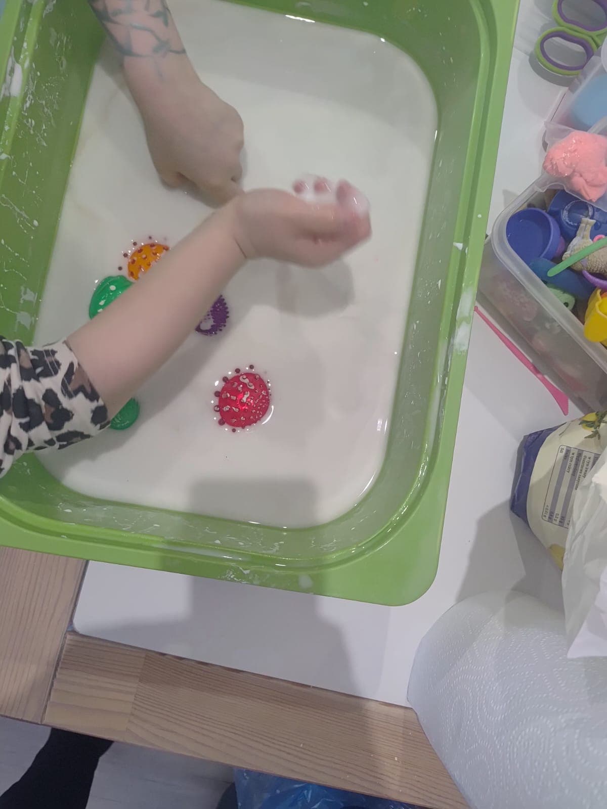 Dziecko wykonuje sensoryczne zadanie manualne przy stoliku.